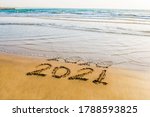 Happy New Year 2021 text on the sea beach. Abstract background photo of coming New Year 2021 and leaving year of 2020