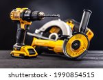 Construction carpentry tools electric corded circular saw cordless drill on background