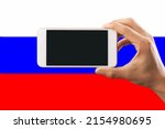Hand holding phone with black screen for logo on  Russia flag background.