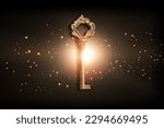 Small photo of Golden key with glowing lights and dark background, wisdom, wealth concept