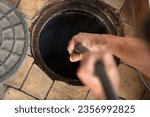 Small photo of Worker performs the installation of pumping equipment. Sewer cleaning