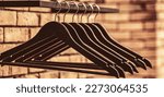 Small photo of Wooden coat hanger clothes. Wood hangers coat. Many wooden black hangers on a rod. Store concept, sale, design, empty hangers.