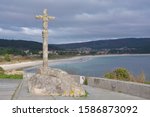 Small photo of Stone cross in Finisterre on the Camino de Santiago, Galicia, Spain. These symbols were built since the XVII century to sanctify the roads and pilgrims who walk to Santiago.