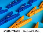 Multi-colored clothespins on a blue background lie in 3 rows.Bright objects.Perfectionism.Household