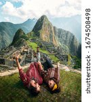 Small photo of Watch this! Happy young tourist couple are on vacation, with ponchos in Machu Picchu