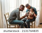 Small photo of Male gay couple with adopted baby girl at home - Two handsome fathers playing with their daughter - Lgbtq+ family at home - Diversity concept and LGBTQ family relationship