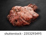 Small photo of Grilled pork gammon on a dark stone background. BBQ menu