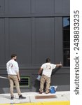 Small photo of Doylestown, PAUSA March 15, 2024. The two workers are painting the exterior of the building.