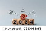 Small photo of 2024 goals of business or life. Wooden cubes with 2024 and goal icon on smart background. Starting to new year. Business common goals for planning new project, annual plan, business target achievement