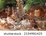 Small photo of excavator crusher machine breaks rocks to widen road