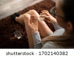 Small photo of Young White Woman at home Holding Two Pain Killer Pills in Her Hand Palm After Spilling from Bottle and Glass of Water. Concept of Pain Relief, Addiction to Opioids and NSAIDs