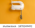 Small photo of Mixer for whipping with two beaters on a yellow background, the concept of minimalism