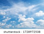 Natural sunny blue sky background with beautiful puffy white cumulus clouds & fluffy cirrus cloudscape on bright daylight horizon in tropical summer sunlight & exotic sun ray at sunny & sunshine day