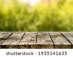 Wooden table or bench on green blurred background. Outdoors
