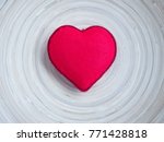 A bright red heart in the middle of wooden plate with free space around it. Ideal of holidays background, banner, backdrop, wallpaper or can be used for love concept.