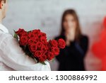 Man holding gift bouquet of red roses for woman. Celebrating Women`s day. Saint Valentine`s day.