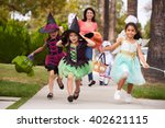 Parent Taking Children Trick Or Treating At Halloween