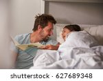 Father Reading Story To Daughter At Bedtime