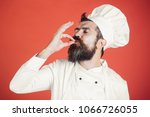 Professional chef man showing sign for delicious. Male chef in white uniform with perfect sign. Serious satisfied bearded chef, cook or baker gesturing excellent. Cook with taste approval gesture.