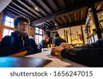 Small photo of Bruges, flanders, Belgium. August 2019. Interior of the historic de garre brewery. The wooden beams, the furniture, the brick walls announce a jump into the past.