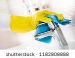 Small photo of Maid hand or charwoman cleaning modern new basin in bathroom, water tap clean using yellow gloves and blue cloth.