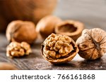 Walnuts kernels on dark desk with color background, Whole walnut in wood vintage bowl.