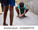Small photo of KOLKATA , INDIA - MARCH 25, 2018: Goli or marbles is a riveting game. At stake are your own marbles which you bring to the arena. Using one's own set of glass balls, players gingerly flick