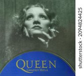 Small photo of Rome, Italy - December 05, 2021, detail of an image of the iconic actress Marlene Dietrich in a book dedicated to her, with CD Greatest Hits II second collection of the British musical group Queen.