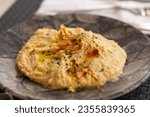 Small photo of Hummus. Large bowl of hummus garnished with paprika and herbs at a restaurant