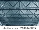 Small photo of Roof or metal ceiling of industrial premises. Inside view. From bottom up. New building. Metal beams and galvanized sheets. Industrial roofing. Background.