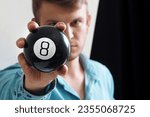 Man shows ball with number to...
