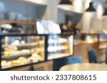 Blurred image of pastry shop interior background. Defocused view of a showcase with confectionery. Bokeh lighting.