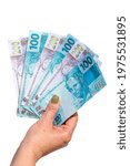 Small photo of woman hand showing one hundred and two hundred reais bills on isolated background