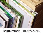 Small photo of Canvas prints, stack of colorful photos with gallery wrapping method of canvas stretching on wooden stretcher bars. Samples of stretched photo canvases. Staple mount, back view