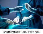 Small photo of doctor and nurse medical team are performing surgical operation at emergency room in hospital. assistant hands out scissor and instruments to surgeons during operation.