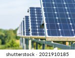 Series or row of solar panels in an agriculture green field in the countryside. Solar power plant. Blue solar panels. Alternative source of electricity. Solar farm. Close up