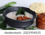 Small photo of Kanji and Kadumanga. Rice gruel prepared with Matta rice. Served in earthen pot in a traditional way with spoon made of jackpot tree leaf. Shot with raw banana curry, cut mango pickle and pappad.