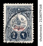 Small photo of Ankara, Turkey - 02,23,2022: A Ottoman Empire stamp shows tugra with red overprint. Circa 1908