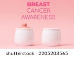 Small photo of Two white porcelain pots with a pink lid on a pink background. Right side pot without lid, symbolizing the disease. Concept of Breast Cancer Awareness Month.