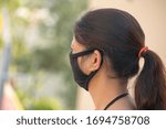 Small photo of Bhopal Madhya Pradesh India 20-march-2020 Arti Malviya in protective Black Mask Back Side view and blur background