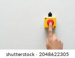 Stop Button and the Hand of Worker About to Press it. emergency stop button. Big Red emergency button or stop button for manual pressing.