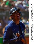 Small photo of Oakland, California - August 21, 2022: Seattle Mariners outfield Julio Rodriguez laughs in the on deck circle during a game against the Oakland Athletics at the Oakland Coliseum.