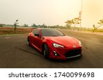 Small photo of Tangerang, Indonesia - November 23, 2018. Red Toyota FT86 standing on the empty road.