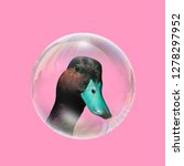 Small photo of Fun art. Concept blue Duckin a bubble on pink background.