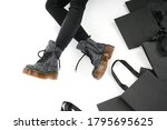  woman in black leather shoes from the new collection on a white background girl's legs in fashionable shoes made of eco-leather autumn-winter 2022. shoe box and bag on a white background             