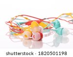 Small photo of Tangled colorful earphones isolated on white background. Multicolored music accesories, summer playlist, radio podcast, digital music application, cacophony, information noise concept. Copy space