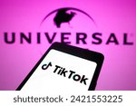 Small photo of February 5, 2024, Brazil. In this photo illustration, the TikTok logo is displayed on a smartphone screen and in the background, logo Universal Music
