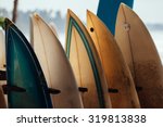 Small photo of Set of different color surf boards in a stack by ocean. WELIGAMA. Surf boards on sandy Weligama beach in Sri Lanka. On Weligama beach surf is available all year around for beginner and advanced.