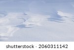 Small photo of Snowy background, snow-covered surface of the earth after a blizzard in the morning in the sunlight with distinct layers of snow