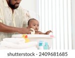 Small photo of Happy African family, father bathing kid in tub, dad washing and cleaning his little toddler girl daughter child in bath. Cheerful toddle baby infant having fun while taking bubble bath in bathroom.